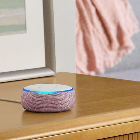 An Amazon Echo Dot smart speaker on a side table.