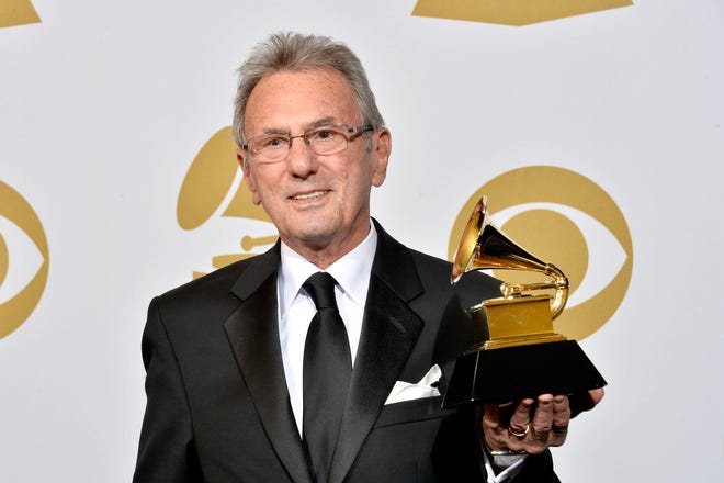 Al Schmitt holds one of his 23 Grammy Awards on Jan. 26, 2014, in Los Angeles. Schmitt died Monday at age 91.
