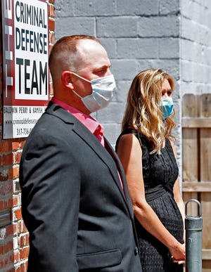 Sean Purdy, left, and Caroline McCord stand outside The Criminal Defense offices in Indianapolis July 13, 2020, as Attorney David Hennessy speaks on their behalf.