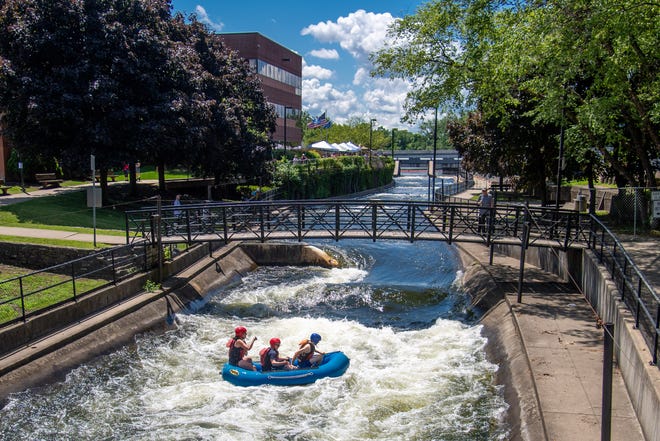 Elizabeth Johnson, left, Paul Johnson, middle, and Daniel Johnson take a whitewater rafting ride down the East Race during Saturday’s Arts on the Race Saturday in South Bend.