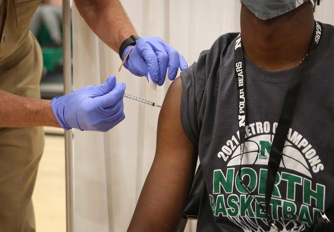 Sekou Mtayari, Jr., a member of the support staff at Des Moines North High School, gets his first of two Pfizer-BioNTech COVID-19 vaccine shots during a clinic in Iowa on Thursday, May 6, 2021.