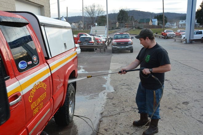 Confluence volunteer firefighter Tyler Byrd washes a department truck Monday in the borough. Temperatures lingered around 60 degrees at times Monday allowing an opportunity for outdoor activities. Staff photo by Eric Kieta