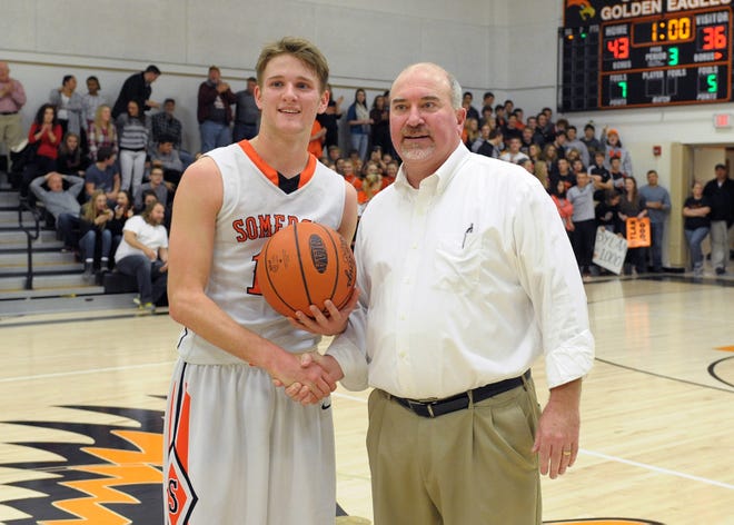 With one minute remaining in the third period, Somerset head coach Scott Close presents Golden Eagles senior Dylan Barnes with the ball in honor of scoring his 1,000th career point in a game with Shanksville on Friday night.