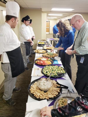Gaylord High School culinary students honored School Board Recognition Month by preparing a diverse spread for the January Gaylord Community Schools Board of Education meeting. Jeff Kuziel (left), Levi Lancaster and Trenton Gentz stand behind a table full of food while helping board of education meeting attendees.