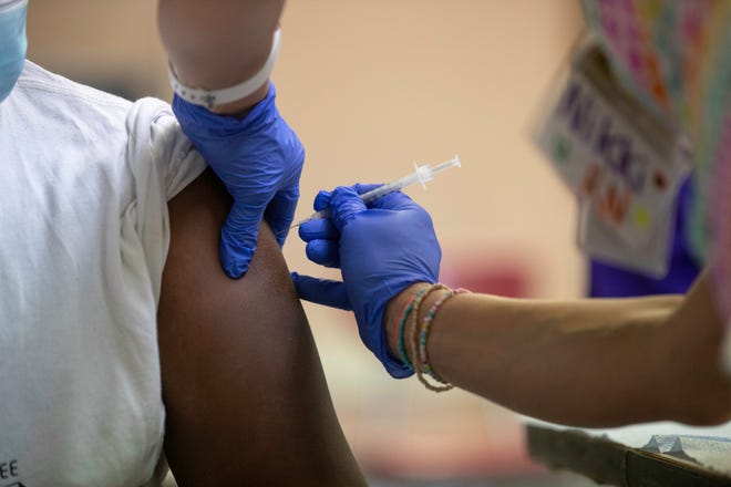 Registered nurse Nikki Mabes administers the COVID-19 vaccine to a student at Morse Middle School for the Gifted and Talented in Milwaukee, Wisconsin, on May 19.
