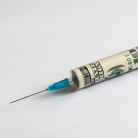 A vaccine syringe with $100 bill rolled up inside 