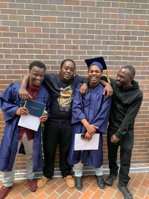 Jeremiah Parker, third from left, stands with his friend and brothers at a graduation ceremony.