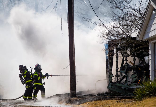 Firefighters work at the scene of a garage fire Thursday, March 4, 2021 on Jackson Street in South Bend.