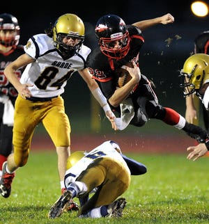 Meyersdale’s Kirk Eberly is upended by Shade’s Tyler Valine, on the ground, while Austin Prosser (84) gives chase in WestPAC action Friday night in Meyersdale.