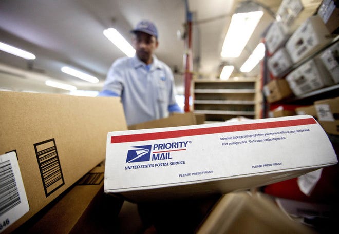 In this Feb. 7, 2013, file photo, packages wait to be sorted in a Post Office as U.S. Postal Service letter carrier Michael McDonald, gathers mail to load into his truck before making his delivery run, in Atlanta.