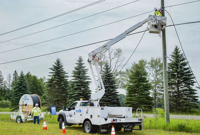A crew attaches fiber cable to utility poles for Truestream, a new fiber internet service being offered by Great Lakes Energy. Provided photo