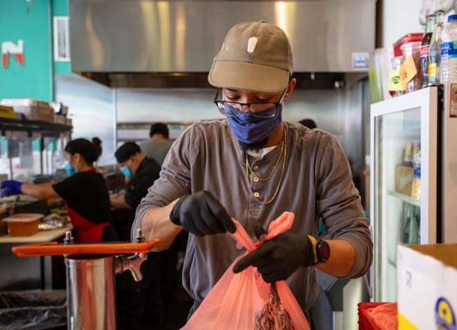 A fast food employee bagging an order.