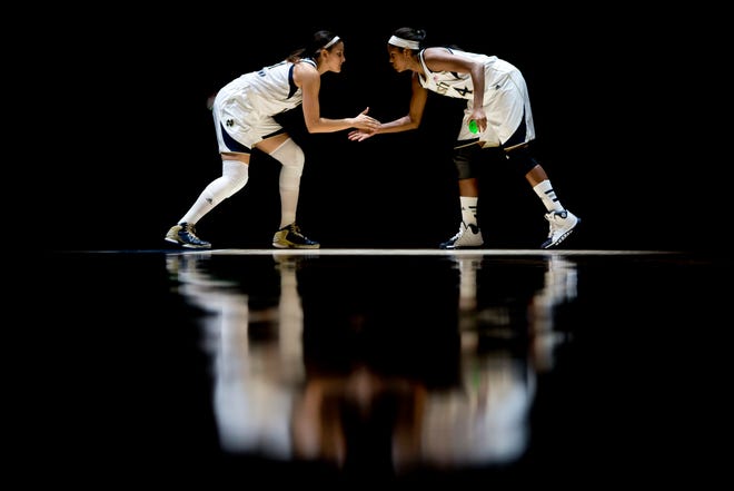 Notre Dame's Natalie Achonwa, left, slaps hands with teammate Ariel Braker as the starting lineup is introduced before a women's NCAA college basketball against DePaul on Tuesday, Nov. 26, 2013, at the Purcell Pavilion at Notre Dame. SBT Photo/JAMES BROSHER