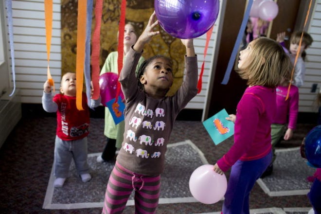Grace Hetler, 6, of South Bend, grabs a balloon after a Playgroup balloon drop marking the New Year on Monday at the former College Football Hall of Fame in downtown South Bend.