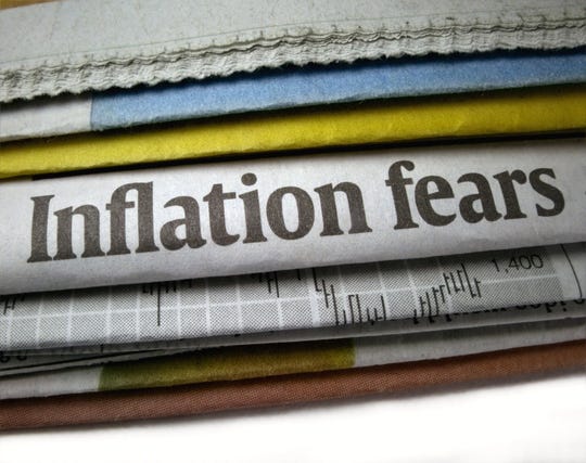 stack of newspapers with headline of inflation fears showing.