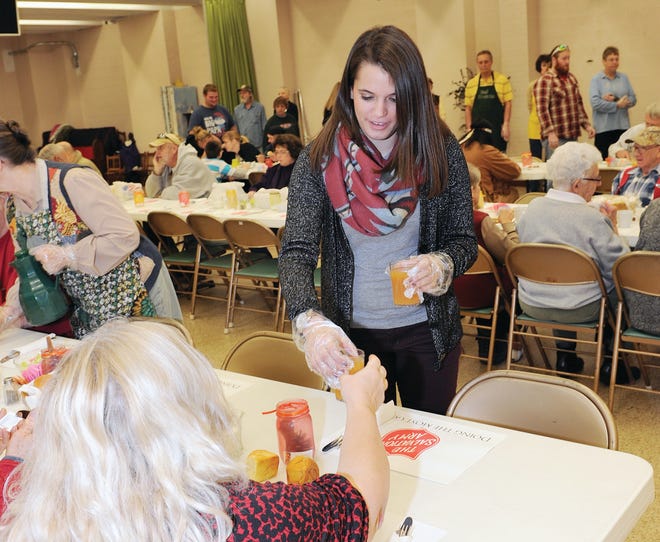 Mia Foust of Somerset helps volunteers from the Salvation Army serve more than 250 Thanksgiving dinners at St. Paul's United Church of Christ in Somerset Thursday.