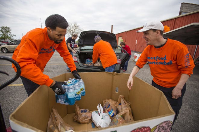 Jamal Griffin, left, and Steve Walisch unload food donations for the Stamp Out Hunger food drive at the Food Bank of Northern Indiana in South Bend Saturday, May 13, 2017. Tribune Photo/MICHAEL CATERINA
