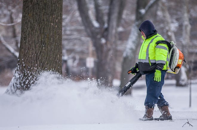 South Bend Venues, Parks &amp; Arts worker Jeff Grzegorek uses a leaf blower to clear snow form a sidewalk at Leeper Park on Monday, Dec. 16, 2019, in South Bend.