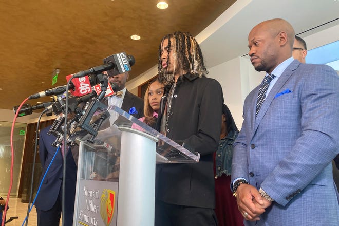 Messiah Young speaks during a news conference accompanied by attorney L. Chris Stewart, right, who represents plaintiff Taniyah Pilgrim, background center, in Atlanta on Thursday. Stuck in traffic, Young and Pilgrim were pulled from their car May 30, 2020, by Atlanta police and are suing the city and officers for excessive force.