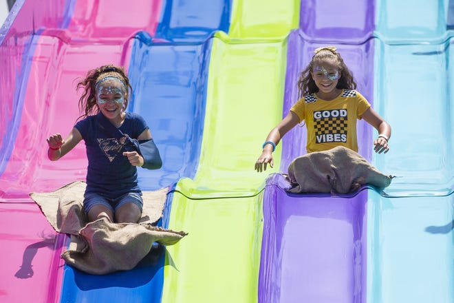 Giselle Slagg, 13, left, and Lolah Slag 11, ride down the slide Saturday at the St. Joseph County 4-H Fair in South Bend.