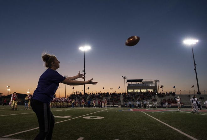 Bloomington High School South football manager Madison Oldham catches a pass Friday in a game of catch with fellow South manager Tess Babcock before the sectional championship between the South Panthers and the Martinsville Artesians at Martinsville High School in Martinsville Friday. Alex McIntyre | Herald-Times