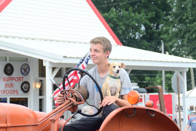 Jacob Higginbotham and dog ride take a ride on their tractor during the annual Coal City Festival parade Saturday. (Kim Howell / Spencer Evening World)