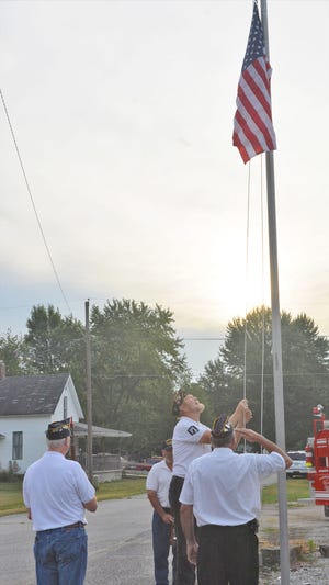 Members of the American Legion Post #141 raise the flag on Saturday morning to kick-off the days festivities. During this time, the National Anthem was sang by Courtney Slough of Coal City. (Kim Howell / Spencer Evening World)