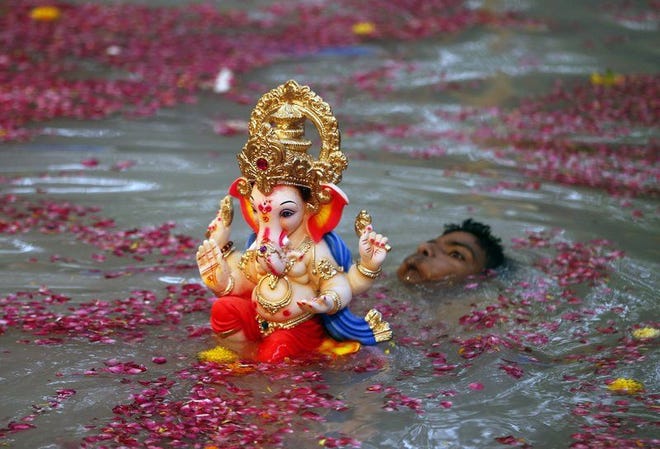A devotee carries an idol of the elephant-headed Hindu god Ganesha, also called Ganesh, into the water to immerse it on Saturday, the second day of the 10-day Ganesh festival, in Mumbai, India.Rajanish Kakade | Associated Press