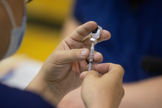 A vaccine is loaded into a syringe at Topeka High School in Kansas in a May 10 event.