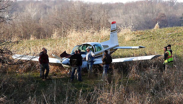 Investigators surround a plane that made an unexpected landing Friday afternoon near Sunny Acres Drive in Bedford. Garet Cobb | Times-Mail