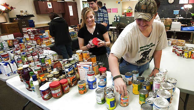 Crystal Blair and Jefferson Wilson sort donated food Friday at Bloomington High School North. The school’s peer mediation group conducted a food drive to provide Thanksgiving meals to families in need that live in the school’s district.David Snodgress | Herald-Times