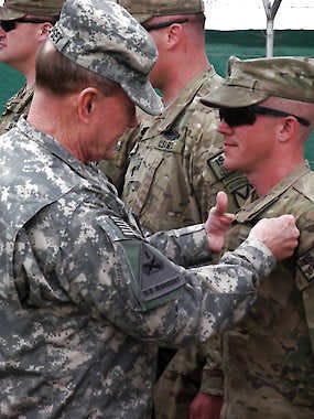 U.S. Chairman of the Joint Chiefs of Staff Gen. Martin Dempsey pins a Combat Infantrymen Badge on an unidentified soldier Sunday at Forward Operating Base Sharana in Afghanistan’s Paktika province. Robert Burns | Associated Press