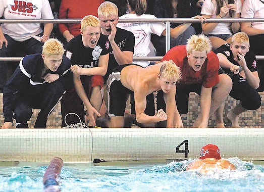 Members of the BNL boys swim team encourage Clayton Orender as he swims the breaststroke portion of the 200 yard medley relay during the Hoosier Hills Conference meet Saturday in Seymour. PETE SCHREINER | Times-Mail
