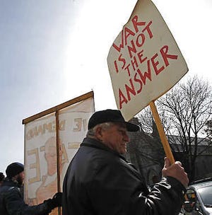 Dave Connor holds a sign March 15 in front of the federal building in Montpelier, Vt.Toby Talbot | Associated Press