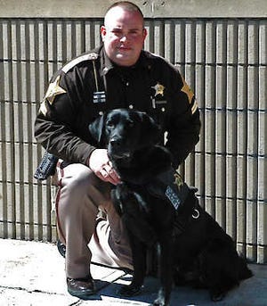 Cpl. Jeremiah Pool poses for a photo with bomb-sniffing dog Pete, a 5-year-old black Labrador retriever, in Indianapolis. After serving three tours of duty in Afghanistan with the U.S. Marine Corps, Pete joined the Marion County Sheriff’s Office five months ago. He’s trained to sniff out explosives and firearms and patrols the City-County Building, home to criminal and civil courts and municipal offices. Diana Penner | Indianapolis Star, Associated Press