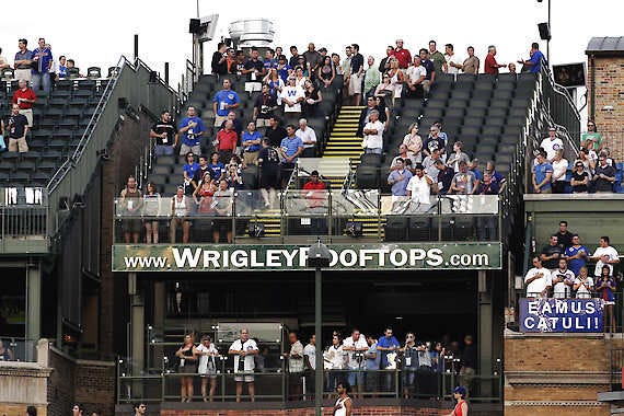 Fans sit in one of the many rooftop venues outside Wrigley to watch a game on Aug. 30, 2010.Charles Rex Arbogast | Associated Press