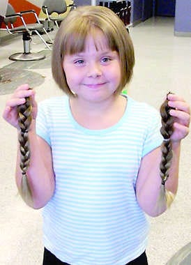 Macee Davenport, Paragon, holds up the braids of hair she donated to Locks of Love on July 10. Submitted photo.
