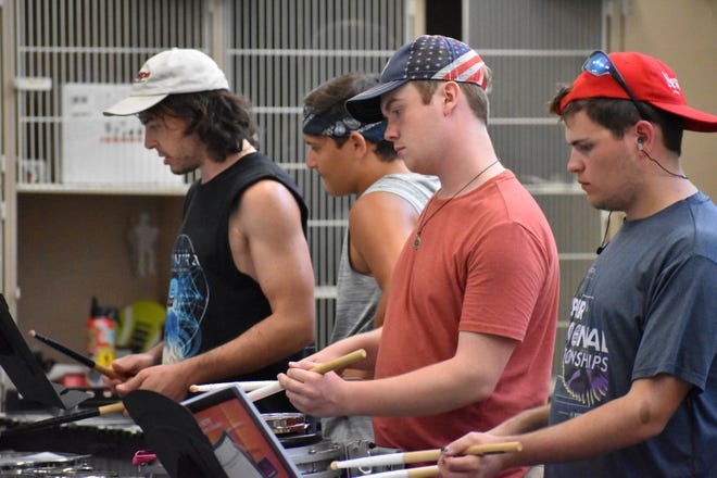 Percussion Tech Danny Walsh works with OV Marching Band members junior Anthony Mertz on tenor drums, senior Conner Rogers on snare drum, and senior Nick Wrightsman on snare drum. (Casey Shively / Spencer Evening World)