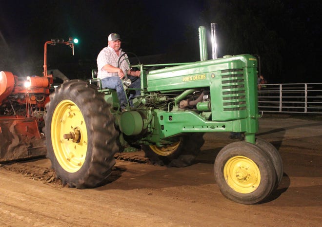 Bob Deckard hauled his John Deere A from Worthington for the tractor pull at the Bowling Green Old Settlers Picnic over the weekend. Deckard’s hook gave announcer Bill Mishler enough material to keep the crowd involved as Deckard ‘putted’ down the track. Even sled owner / operator Larry Stephen joined in the fun by manually pushing the sled for a joke. (Krista Dayhoff / Spencer Evening World)