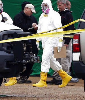 Federal authorities, some in hazmat suits, walk outside the staging area Wednesday as they search a small retail space where neighboring business owners said Everett Dutschke used to operate a martial arts studio in Tupelo, Miss., in connection with the recent ricin attacks. No charges have been filed against Dutschke and he hasn’t been arrested.Rogelio V. Solis | Associated Press