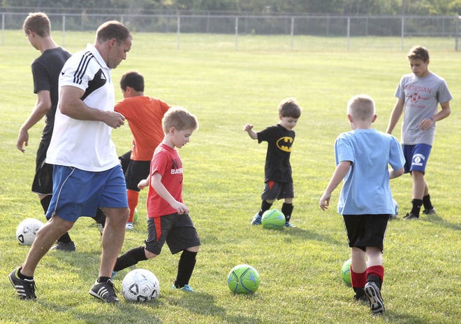 Martinsville boys’ soccer coach Daniel Urban shows campers how to dribble during Tuesday’s boys’ soccer camp.