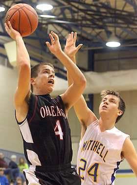 MITCHELL — Jarrett Jones shoots for Orleans with pressure from Mitchell’s Chad Phillips Tuesday night. (Times-Mail / PETE SCHREINER).