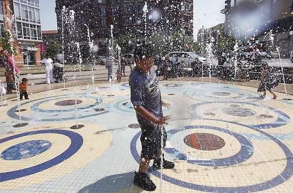 In this AP photo, a young boy keeps cool in a fountain in Washington, D.C.