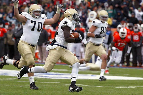 Notre Dame running back Cierre Wood (center) heads toward the end zone as teammate Dennis Mahoney (70) celebrates in the Sun Bowl against Miami (Fla.) Friday. Reuben Ramirez | Associated Press