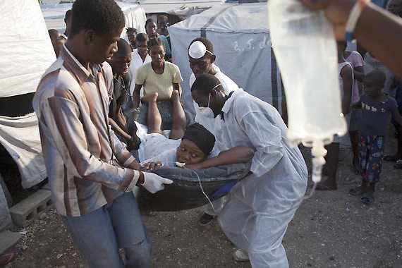A woman suffering cholera symptoms is carried to a hospital Saturday at an earthquake refugee camp in Port-au-Prince, Haiti.Ramon Espinosa | Associated Press