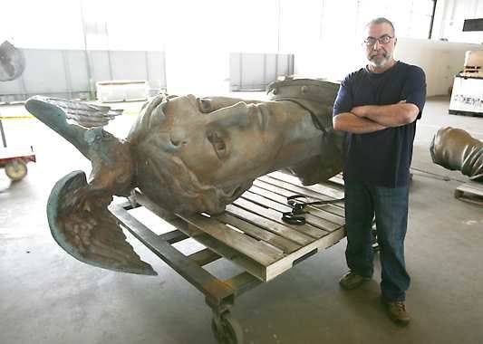 Georgie Gikas, president and chief conservator for Venus Bronze Works stands by pieces of the Victory sculpture from atop the Soldiers and Sailor monument on the circle at Stout Field in Indianapolis. He is working to repair cracks and holes in the 38-foot-tall sculpture, which will get a new skeleton and will be pressure-washed before being put back in place this fall.Michelle Pemberton | Associated Press