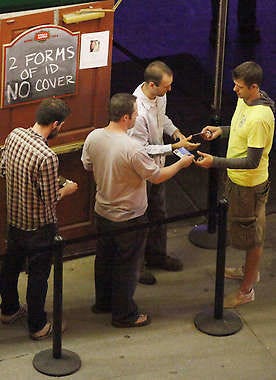 A doorman at Kilroy’s Sports bar checks identification Friday night. The bar requires two forms of ID, but only one has to have a photograph.Jeremy Hogan | Herald-Times