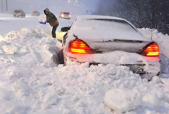 Roy Williams of Westfield, Mass., shovels snow in front of his vehicle on a merge ramp on Interstate 91 during a winter storm Wednesday in Windsor, Conn. Williams said a plow clearing the highway passed by and blocked him in.Jessica Hill | Associated Press