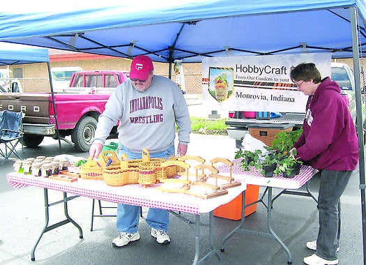 Lannie and Cindy Andrews get their baskets, crafts, plants and jellies ready for the Mooresville Farmer\'s Market, now in a new location at the Mooresville Consolidated School Corp. Education Center on Carlisle Street. The opening day was Wednesday. The Andrews are from Monrovia. Photo by Amy Hillenburg.