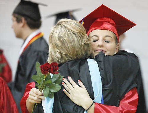 Edgewood High School graduate Jaclyn Ennis, facing, gets a hug from cheerleading coach Kristi Parker. Jeremy Hogan | Herald-Times